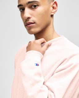 A model wearing a grey Champion Reverse Weave® adult crew sweatshirt, showcasing a casual style.