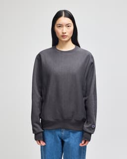 A dark grey women's crew sweatshirt with long sleeves and a logo detail on the sleeve.