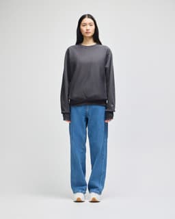 A grey Champion Reverse Weave® adult crew sweatshirt on a model, paired with blue jeans and white sneakers.
