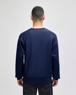 A navy blue adult crew sweatshirt with a relaxed fit, featuring a logo on the back.
