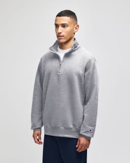 A grey quarter-zip pullover jacket designed for adults, featuring long sleeves and a logo on the sleeve.