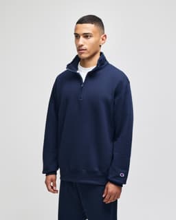 A navy blue quarter-zip pullover featuring a stand-up collar and a small logo on the sleeve.