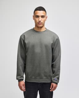 A grey sweatshirt featuring a crewneck design and a logo on the sleeve.