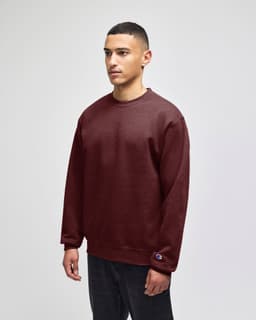 A burgundy crewneck sweatshirt with long sleeves, featuring a logo on the hem.