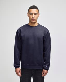 A navy blue crewneck sweatshirt with a logo on the sleeve, featuring a relaxed fit and long sleeves.
