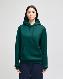 A green hooded sweatshirt featuring a front pocket and a logo on the sleeve.