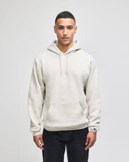 A light beige pullover hooded sweatshirt with a front pocket and a logo on the sleeve.