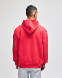 A red pullover hooded sweatshirt with a view of the back. It features a hood and a relaxed fit.