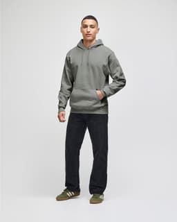 A grey hooded sweatshirt with a front pocket, paired with navy shorts and brown shoes, featuring a logo.