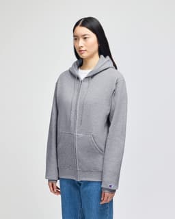 A grey full-zip hooded sweatshirt with a front pouch pocket and a logo on the sleeve.