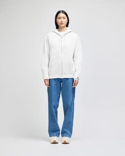 A grey full-zip hooded sweatshirt with a front pocket and a logo, paired with blue jeans.