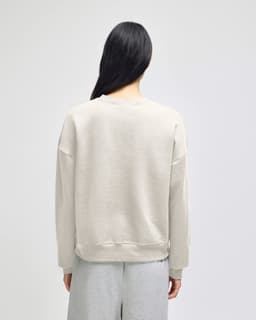 A women's crewneck sweatshirt in light grey, featuring a relaxed fit and simple design on the back.