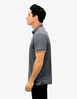 A grey polo shirt with orange accents, featuring a collar and short sleeves, on a model from the side.