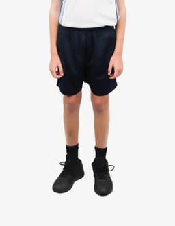 Sports shorts in navy blue, worn by a child standing with hands at their sides, paired with black shoes and socks.