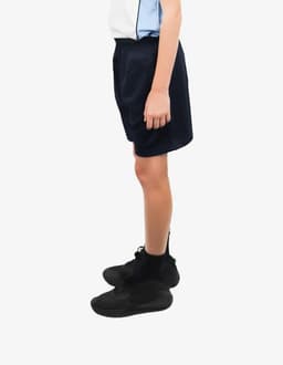 Sports shorts in navy blue, featuring an elastic waistband, displayed on a standing model with black footwear.