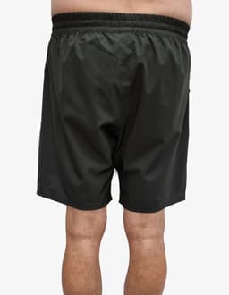 Sports shorts in a dark green colour with an elastic waistband, featuring a logo on the side.