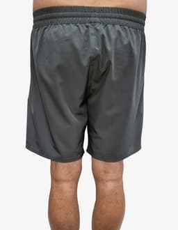 Sports shorts in a dark green colour, featuring an elastic waistband and a smooth fabric. The image depicts the back view.