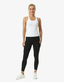 A person in a white top and black leggings performs a yoga pose against a plain background. The leggings feature a logo.