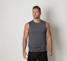 A grey sleeveless shirt is worn by a man standing against a plain background. The shirt features a logo.