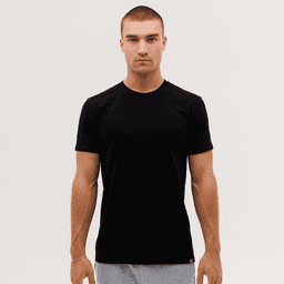 A black T-shirt displayed on a male model against a plain background, featuring a logo on the hem.