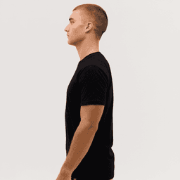 A black t-shirt is displayed on a model, shown from the side profile against a plain background.