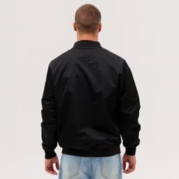 A black bomber jacket viewed from the back, featuring a simple design and ribbed cuffs.