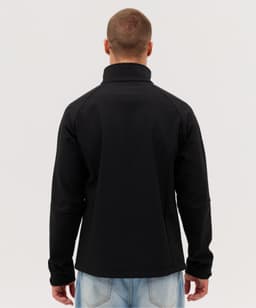 A black Prime Softshell Jacket is displayed from the back, featuring a high collar and a fitted design.