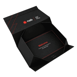 A small black gift box with red accents and an internal greeting message. It features a logo and a ribbon.