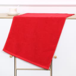 A vibrant red gym towel draped over a shelf, featuring a contrasting trim and a logo.