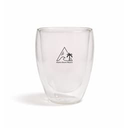 A double-walled glass cup with a transparent design and a logo featuring a mountain and palm tree.