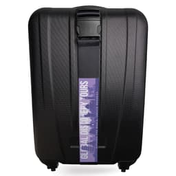 A black hard-shell suitcase with a luggage strap featuring a logo across the front.
