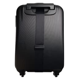 A black suitcase featuring a sleek luggage strap securing it in place.