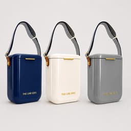 A set of three Pavilion Coolers in navy, cream, and grey, each with a strap and a logo.