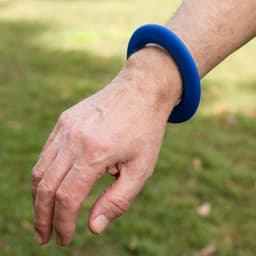 A blue silicone wrist flyer is worn on a person's wrist.
