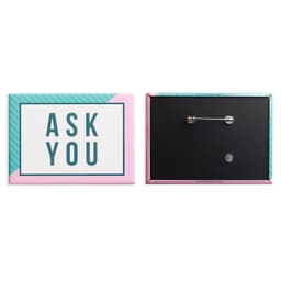 A rectangular badge in pink, turquoise, and white featuring a pin back.