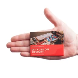 A hand holds a rectangular promotional badge with a red border, featuring various images and a logo.