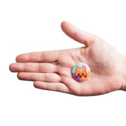 A hand holds a vibrant custom printed 32mm round magnet featuring a colourful design.