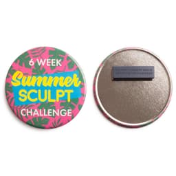A round badge featuring a vibrant pink and green tropical design with a magnet on the back.