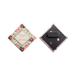 A diamond-shaped badge with floral design, featuring a magnetic back for attachment. Includes a cautionary note about magnetism.