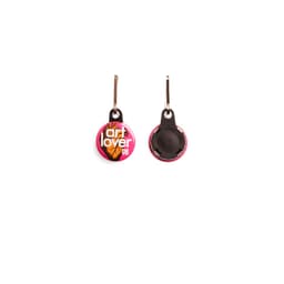 A pink 25mm round zipper pull featuring a logo and a loop for attachment.