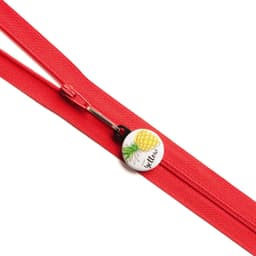 A red zipper with a custom printed 25mm round zipper pull featuring a yellow pineapple design.