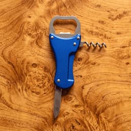 A drink bottle opener in blue, featuring a knife, corkscrew, and a bottle opener, set on a wooden background.