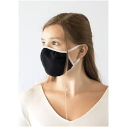 A black face mask with white ear straps, worn by a model with long hair, against a plain background.