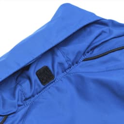 A blue jacket featuring a velcro fastening at the collar and a logo. Suitable for various outdoor activities.