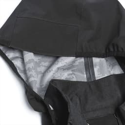 A black softshell jacket featuring a patterned interior and a hood, with a visible brand logo.