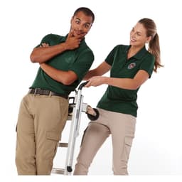 Two models wear green short sleeve polo shirts, posing with a ladder, showcasing the shirts' fit and style.