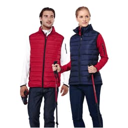 A red and navy insulated vest worn by a man and a woman, both holding trekking poles and wearing casual clothing.