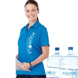 A woman in a blue polo shirt holds a document next to two water bottles. The shirt features a logo.