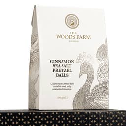 A bag of 100g cinnamon sea salt pretzel balls in a white and gold design, featuring a peacock motif.
