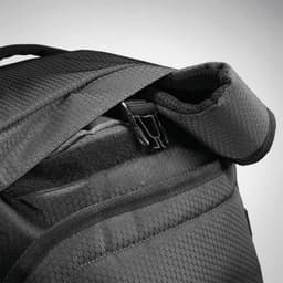 A black duffel backpack with a textured fabric and zippered opening, featuring padded shoulder straps.